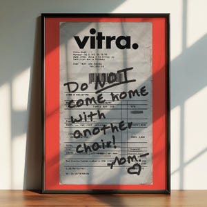 May include: A red framed poster with a white receipt inside. The receipt has black text that says "Vitra" and "Do NOT come home with another chair!" The receipt also has a barcode and a handwritten note that says "Nom".