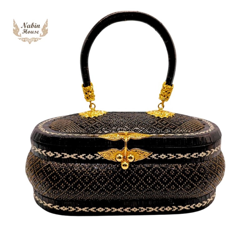 May include: A black woven handbag with a gold handle and decorative accents. The bag has a woven pattern and a white trim.