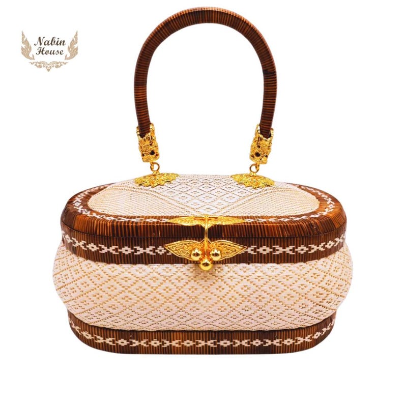 May include: A white and brown woven handbag with a gold clasp and handle. The bag has a traditional woven pattern and is decorated with gold accents.