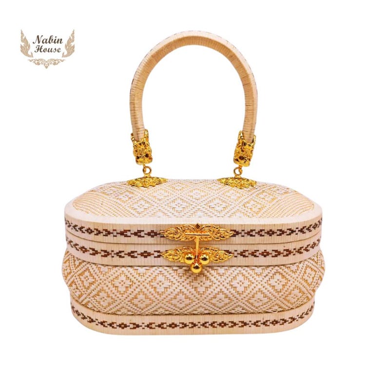 May include: A white woven handbag with a gold handle and a gold clasp. The bag has a geometric pattern and a brown trim.