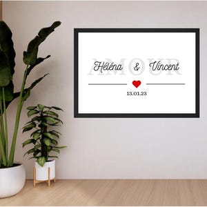 Peut inclure: Impression encadrée en noir et blanc avec le texte "Heléna & Vincent" et un cœur rouge. La date "13.01.23" est imprimée sous le cœur.