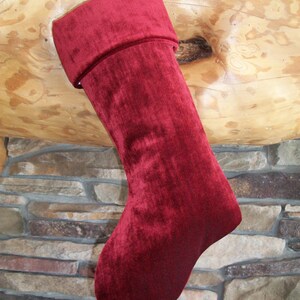 May include: A red velvet Christmas stocking with a white and black striped top.