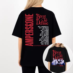 May include: Black t-shirt with red text. The text on the back reads "AMPERS&ONE" vertically and "Born to Define" with a list of tour dates. The shirt also has a smaller image of the band on the front.