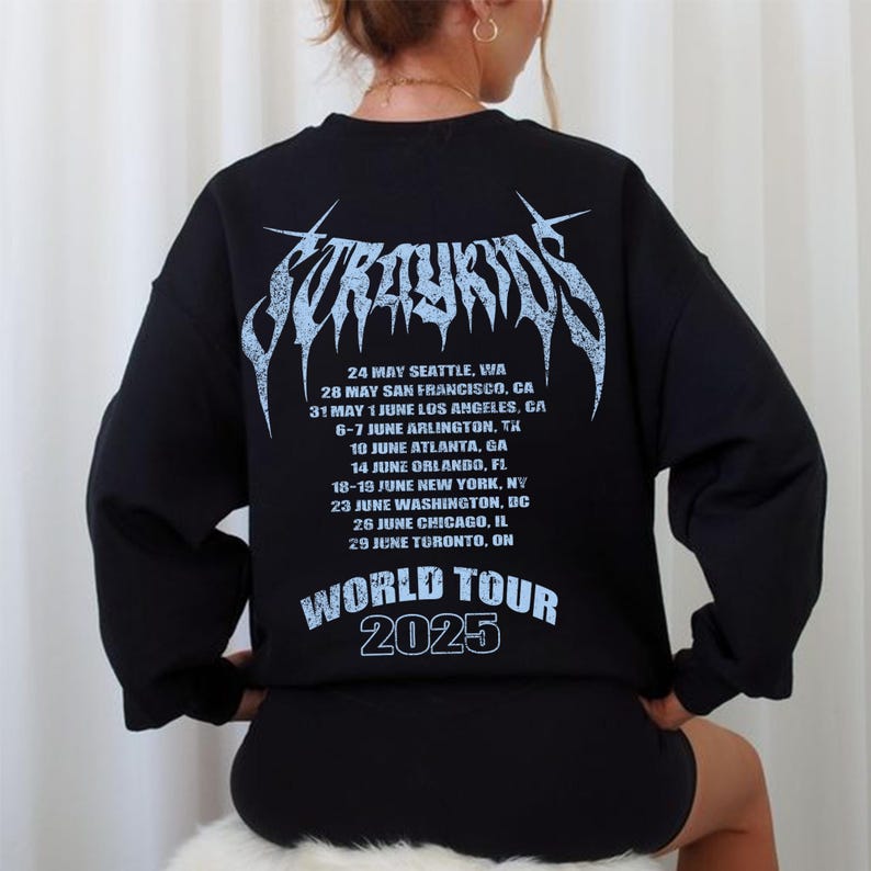 Puede incluir: Sudadera negra con un dise&ntilde;o gr&aacute;fico azul claro en la espalda. El dise&ntilde;o incluye el texto "Stray Kids" en una fuente estilizada, una lista de fechas de la gira y las palabras "World Tour 2025".