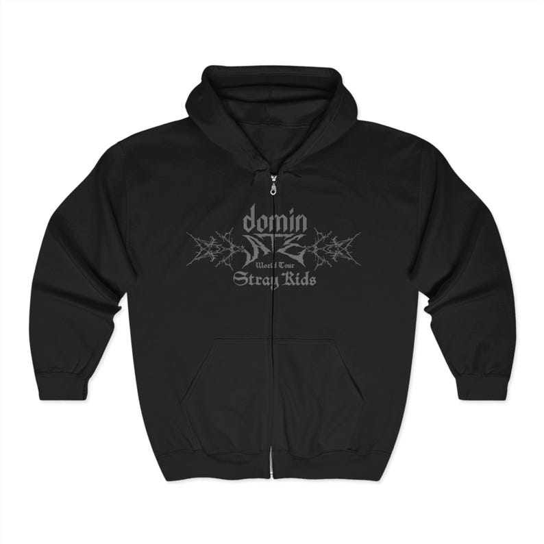 K&ouml;nnte beinhalten: Schwarzer Kapuzenpullover mit Rei&szlig;verschluss, Kapuze und Vordertaschen. Der Hoodie hat eine silberne Grafik auf der Brust mit der Aufschrift "domin" &uuml;ber "World Tour" und "Stray Kids". Der Hoodie hat einen durchgehenden Rei&szlig;verschluss.