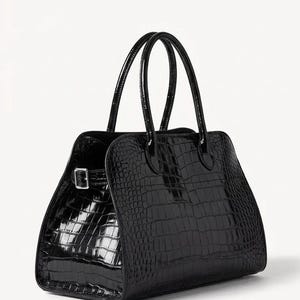 May include: A glossy black handbag with a crocodile skin texture. The bag has two top handles and a rectangular shape with a buckle closure. The bag is set against a white background.