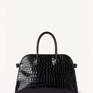 May include: Black, glossy handbag with a textured, crocodile-like pattern. The bag has a curved top, a short handle, and small metal accents on the sides. The bag is set against a white background.