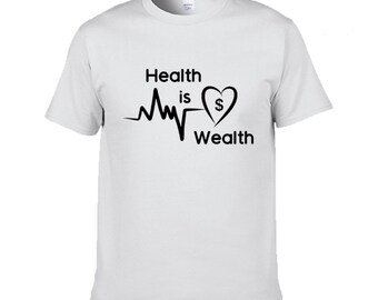 Puede incluir: Camiseta blanca con un diseño gráfico negro que dice "Health is Wealth" con un símbolo de corazón que contiene un signo de dólar.