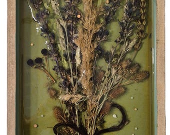 May include: A rectangular resin art piece featuring dried flowers and a butterfly against a green background. The bouquet is tied with a dark twine and rests on a bed of small stones, encased in a wooden frame.