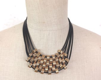 Multi-Strand Black Cord Necklace with Gold Tone Woven Pendant
