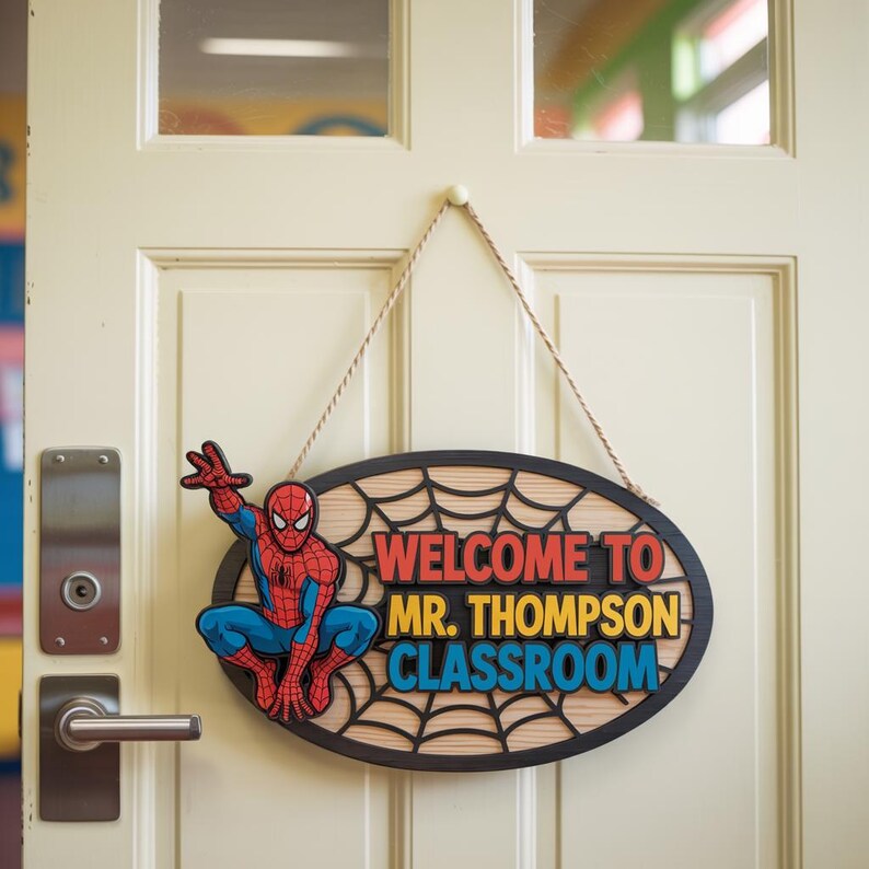 May include: Oval wooden classroom sign featuring Spider-Man and the text "WELCOME TO MR. THOMPSON CLASSROOM." The sign has a black border and a spiderweb design. The sign is hanging on a cream-colored door.