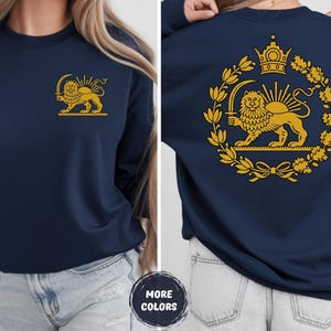 May include: Navy blue sweatshirt with a gold lion and sun emblem on the front and back. The emblem includes a crown, sword, and laurel wreath. The sweatshirt is a long-sleeved crew neck.