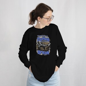 May include: Black long-sleeve shirt with a graphic of a skeleton sitting on a couch with a coffee mug. The text on the shirt reads "Time for a Coffee Break".