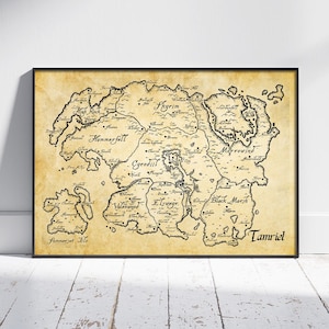 May include: A framed map of Tamriel, with detailed black line art on a parchment-style background. The map includes geographical features and place names, set within a black frame. The design evokes a vintage or fantasy aesthetic.