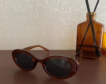 Gafas de sol retro marrones con montura ovalada estilo carey, protección UV de inspiración vintage.
