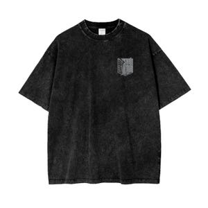 Op de afbeelding: Zwart T-shirt met een verbleekte look en een grijs geborduurd embleem van een gevleugeld symbool op de linkerborst.