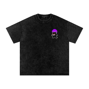 Pode incluir: T-shirt preto de manga curta com um aspeto desbotado e texturizado. Um pequeno gráfico de um personagem de desenho animado com uma cabeça roxa e um sorriso vermelho está no peito esquerdo. A camisa tem gola redonda e um corte folgado.