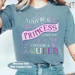 May include: Blue jean comfort color t-shirt with the text "WHY BE A PRINCESS WHEN YOU COULD BE A QUEEN" in purple, pink, and green. The design includes a banner, skull, and other decorative elements.