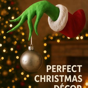 May include: A green hand with long fingers wearing a red sleeve with a white cuff, holding a silver spherical ornament. The text LIFE-SIZE 29cm and PERFECT CHRISTMAS DÉCOR is visible. The hand is positioned against a blurred background of lights.