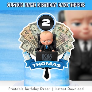 Puede incluir: Un adorno para tarta de cumpleaños personalizado con un personaje de bebé jefe de dibujos animados. El adorno incluye el nombre "Thomas" y el número "2". El diseño incorpora billetes de dólar y una base de tarta azul.
