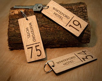 May include: Wooden hotel keychains with the text "WHITEFORD HOTEL" and room numbers 19, 75, and 34. The keychains are rectangular with a silver key ring. The keychains are on a piece of wood.