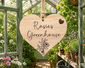 May include: A heart-shaped wooden sign hanging from a jute rope. The sign features the engraved text "Rosie's Greenhouse" in a cursive font, a small engraved heart in the upper right corner, and a floral bouquet illustration at the bottom.