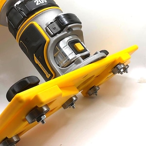 May include: A yellow and black power tool with a silver and black motor housing. The tool has a 20V label and the word "BRUSHLESS" is visible. The tool has a yellow base with several small wheels.