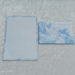 May include: A blue and white stationery set with a butterfly design. The envelope features a butterfly with the text "The flapping wings of butterflies are resonating with freedom".