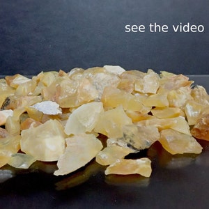 May include: A pile of yellow and orange opal rough stones. The stones are various sizes and shapes.