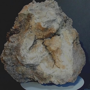 May include: A large, irregularly shaped rock with a rough, brown exterior and a white, crystalline interior. The rock has a natural, organic look and feel.