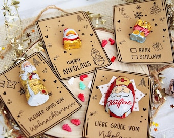 May include: A collection of festive greeting cards with chocolate Santa figures. The cards are brown with black illustrations and text, including "Happy Nikolaus" and "Kleiner Gruß vom Weihnachtsmann". Decorative elements include stars and candy.
