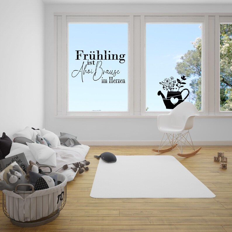 May include: A window decal with the text "Fr&uuml;hling ist  Ahoi Brause im Herzen" and a silhouette of a watering can with flowers. The decal is on a window in a room with a white rocking chair and a white rug.