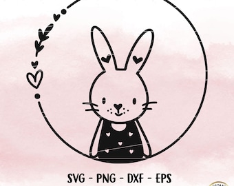 May include: Black and white line art illustration of a bunny wearing a dress with hearts. The bunny is inside a circle with a wreath of leaves and hearts around it.