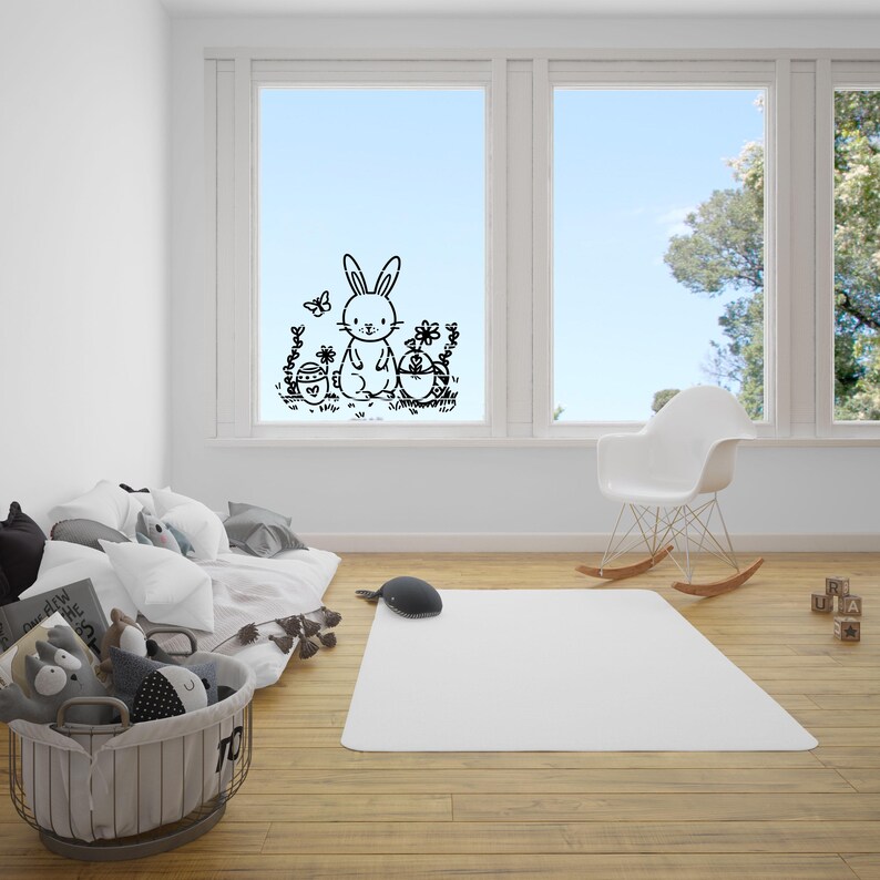 May include: A black and white illustration of a bunny rabbit holding an Easter egg, with a butterfly and flowers in the background. The illustration is on a window sticker.