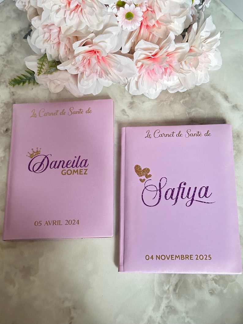 May include: Two light purple notebooks with gold lettering and the text "Le Carnet de Sant&eacute; de". One notebook has the name "Daneila Gomez" and the date "05 AVRIL 2024". The other notebook has the name "Safiya" and the date "04 NOVEMBRE 2025".