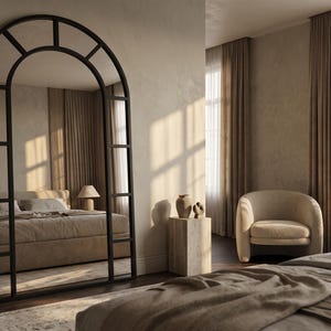 May include: A large, floor-standing arched mirror with a black metal frame divided into rectangular panes. The mirror features a curved top section and a grid-like structure, reflecting a bedroom interior with a bed, bedding, and a lamp.