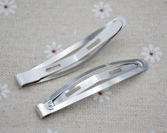 May include: Two silver metal hair clips. The clips are about 5 cm long and have a curved shape.