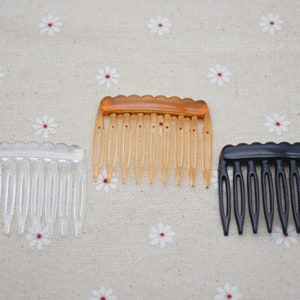 Puede incluir: Tres peines para el cabello de plástico en diferentes colores: transparente, ámbar y negro. Los peines tienen una parte superior ondulada y están diseñados para peinar el cabello.