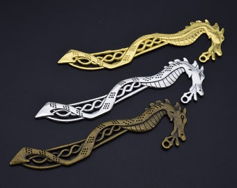 May include: Three metal dragon bookmark charms in gold, silver, and bronze. Each charm features a detailed dragon design with intricate knotwork.