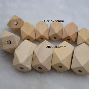 May include: A group of 10 natural wood geometric beads in two sizes. The larger beads measure 20x20x30mm and the smaller beads measure 15x15x22mm. The beads have a hole in the center for stringing.