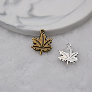 May include: Two metal maple leaf charms, one in antique gold and one in silver.