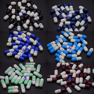Puede incluir: Seis pilas de c&aacute;psulas coloridas con una carita sonriente en cada una. Las c&aacute;psulas son blancas con detalles en negro, azul, azul claro, verde, granate y azul oscuro.