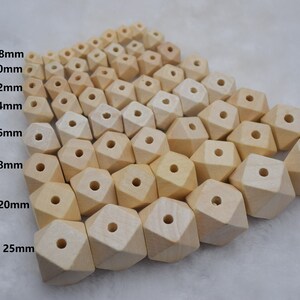 Może przedstawiać: Kolekcja niewykończonych drewnianych koralików w różnych rozmiarach, od 8 mm do 25 mm. Koraliki mają geometryczny, fasetowany kształt i otwór pośrodku, idealne do projektów rzemieślniczych.