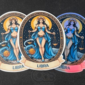 May include: Three colourful stickers featuring a woman in a blue dress holding a scale. Each sticker has a gold border and the word "LIBRA" written on a banner at the bottom.