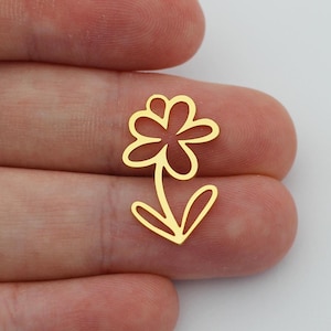 May include: Two gold-colored metal flower charms with a simple, hand-drawn design. The charms are small and delicate, perfect for adding a touch of whimsy to jewelry or crafts.
