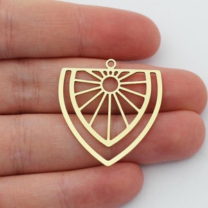 May include: Two gold-colored metal earring blanks with a geometric sunburst design. The blanks have a hole at the top for attaching earring wires.