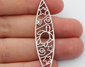 Puede incluir: Encanto de plata en forma de tabla de surf con un diseño recortado de una tortuga, conchas y estrellas.