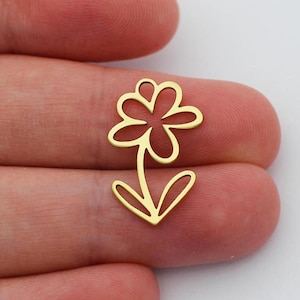 May include: Two gold-colored metal flower charms with a simple, hand-drawn design. The charms are about 1 inch tall and are perfect for adding a touch of whimsy to jewelry or crafts.
