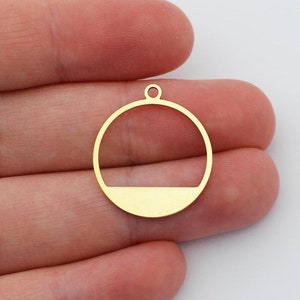 May include: Two gold-colored metal circle pendant charms with a horizontal line across the center. The charms have a hole at the top for attaching to a chain or cord.