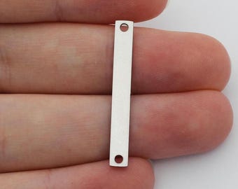 May include: Two silver metal bar connectors with two holes each. The bars are flat and rectangular.